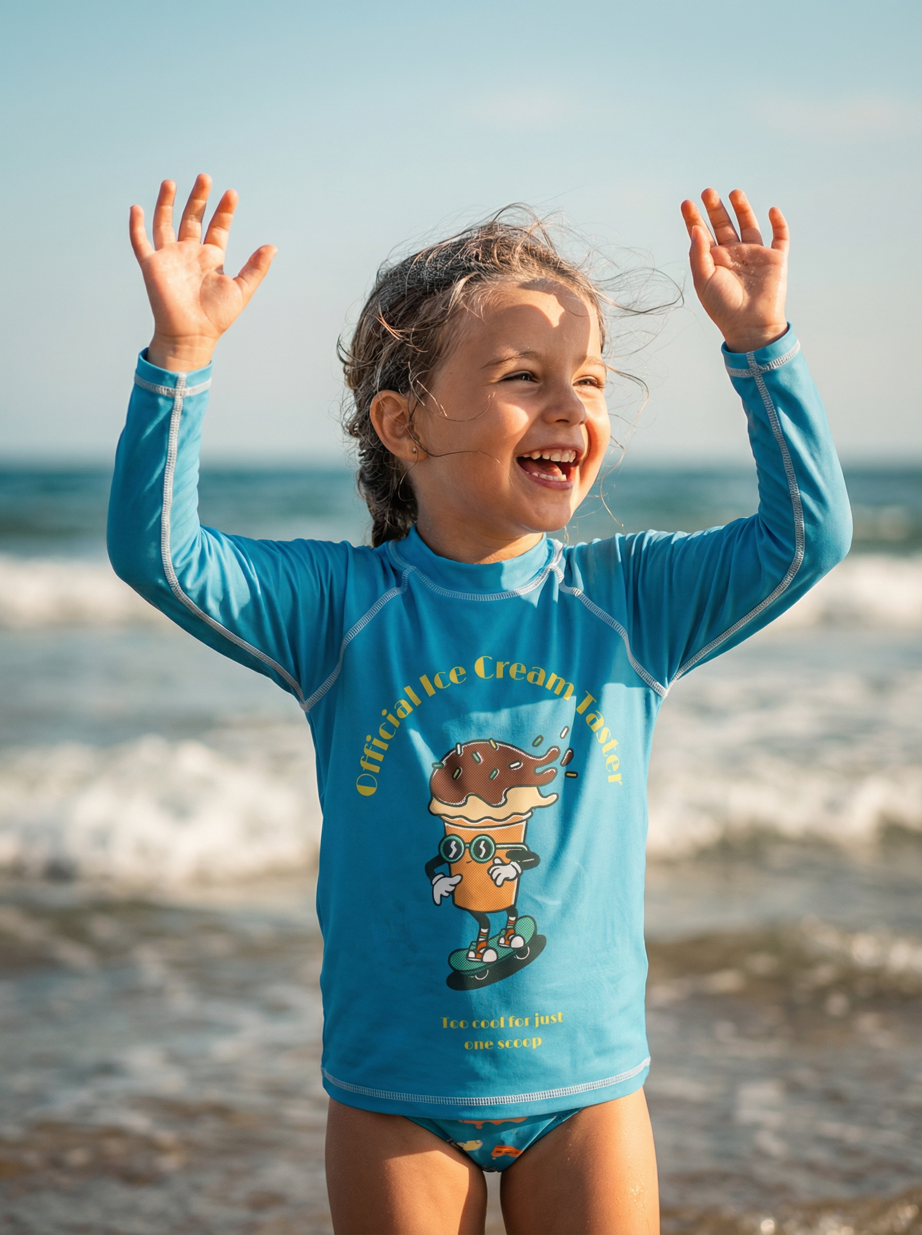 Child wearing a blue shirt with a cartoon character on a beach