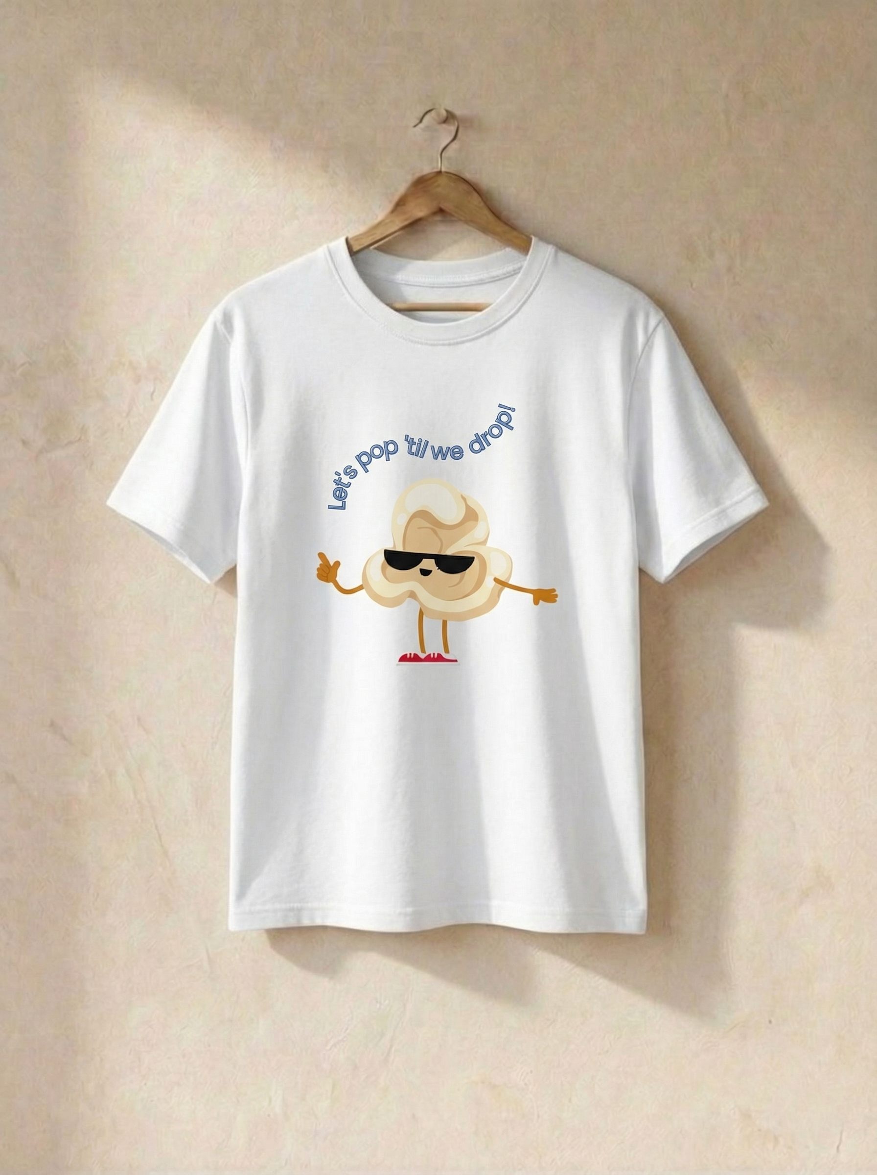 White t-shirt with cartoon design and text on a beige background