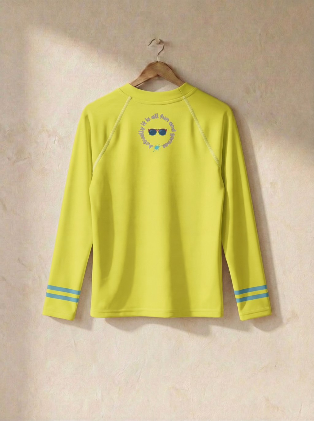Yellow long-sleeve shirt with a logo on a beige wall