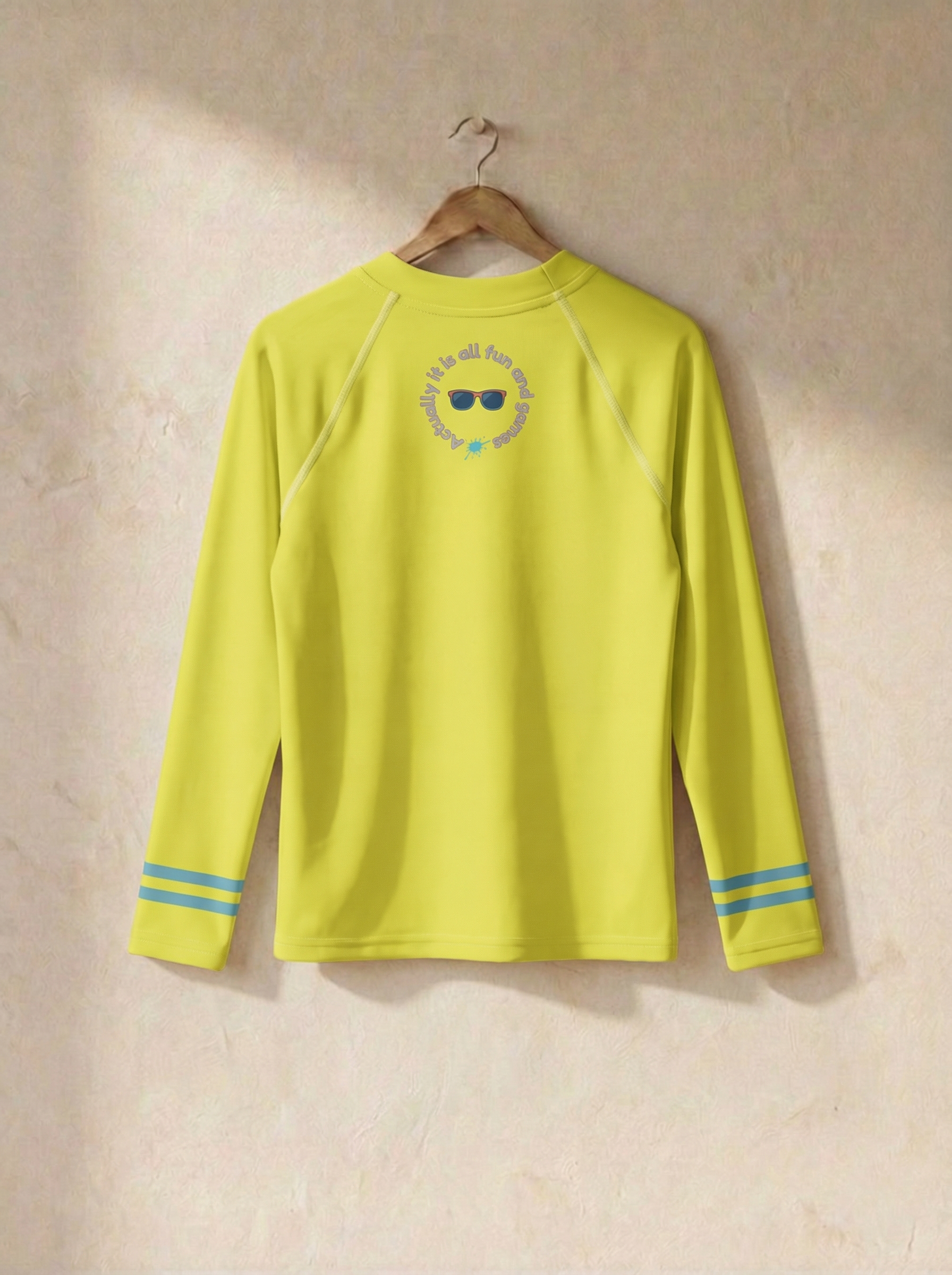Yellow long-sleeve shirt with a logo on a beige wall