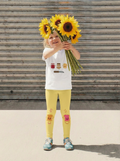 Child holding sunflowers in front of a wooden background